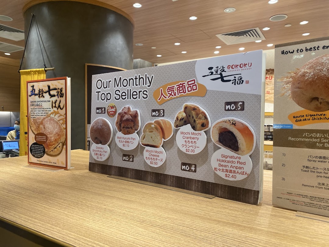 A display board showcasing Gokoku Japanese Bakery's monthly top-selling bread items with prices.