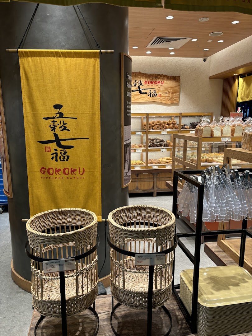 The inviting entrance of Gokoku Japanese Bakery, featuring a traditional banner and a glimpse of fresh baked goods.