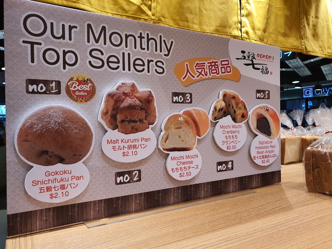 A display board showcasing Gokoku Japanese Bakery's 'Monthly Top Sellers' with product images and prices.
