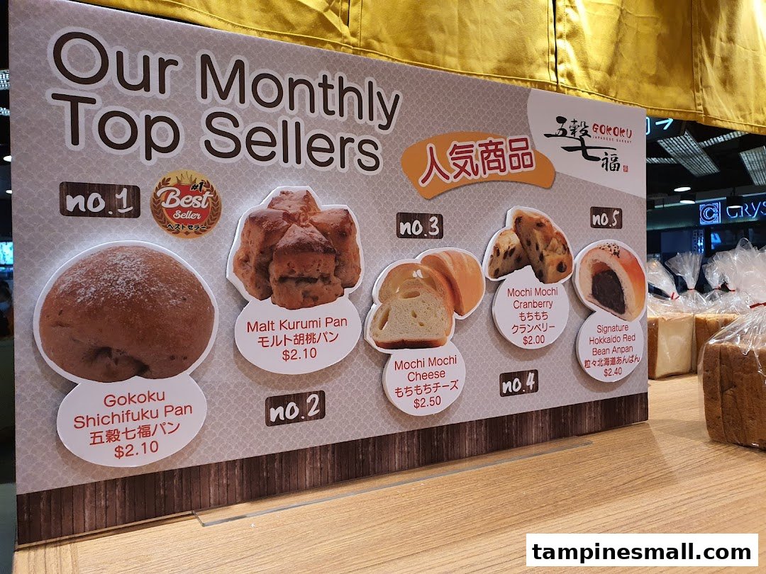 A display board showcasing Gokoku Japanese Bakery's 'Monthly Top Sellers' with product images and prices.