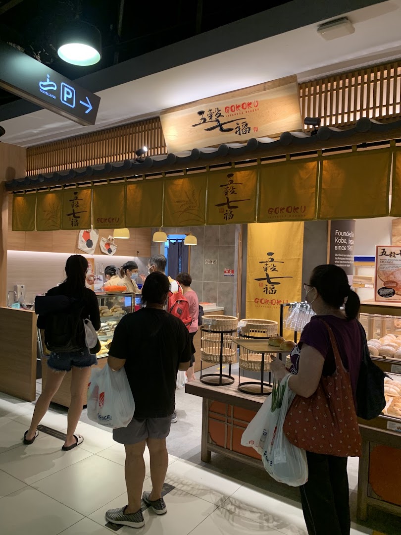 Customers browse freshly baked goods at the inviting entrance of Gokoku Japanese Bakery.