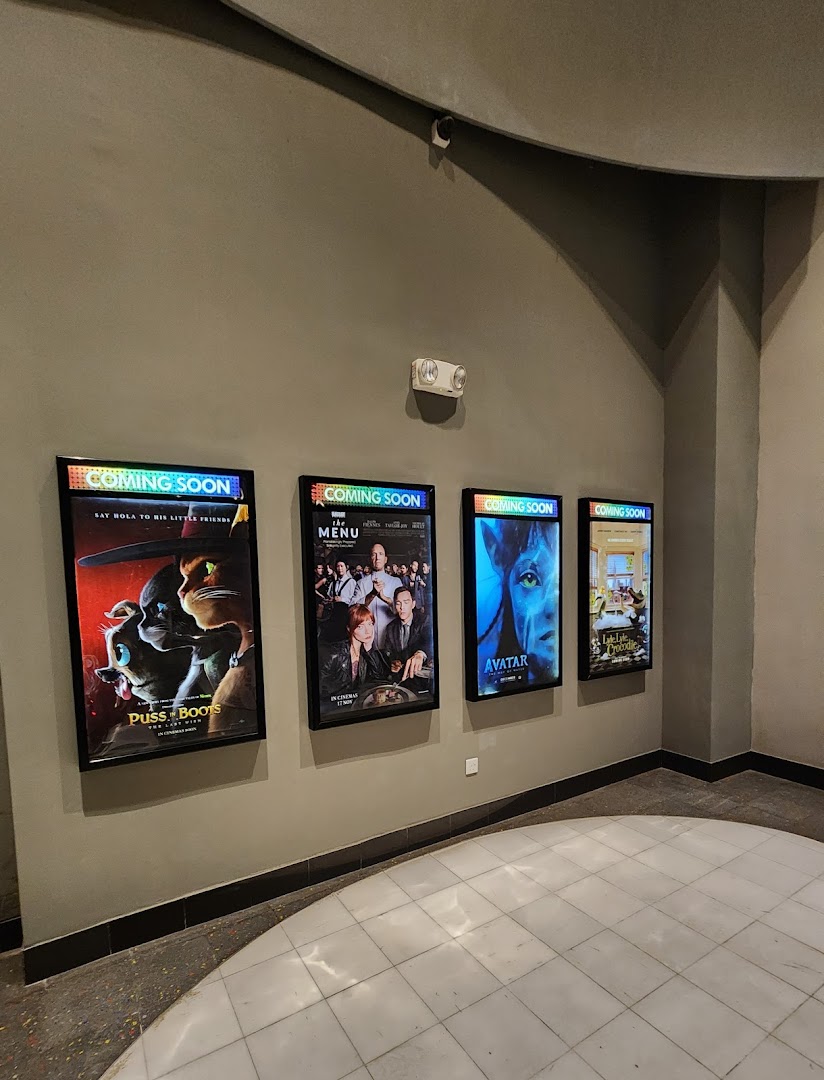 Movie posters for 'Coming Soon' films displayed in a cinema lobby.