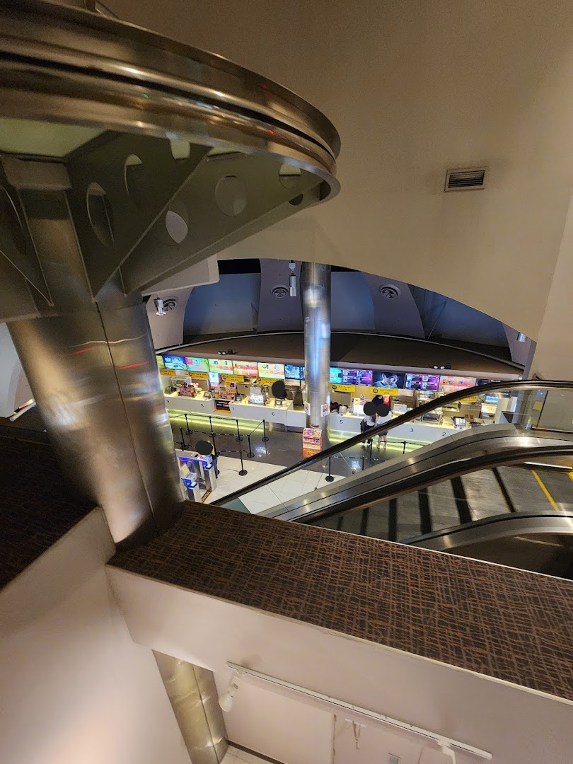 An elevated view of Golden Village Tampines cinema lobby, featuring concession stands and escalators.