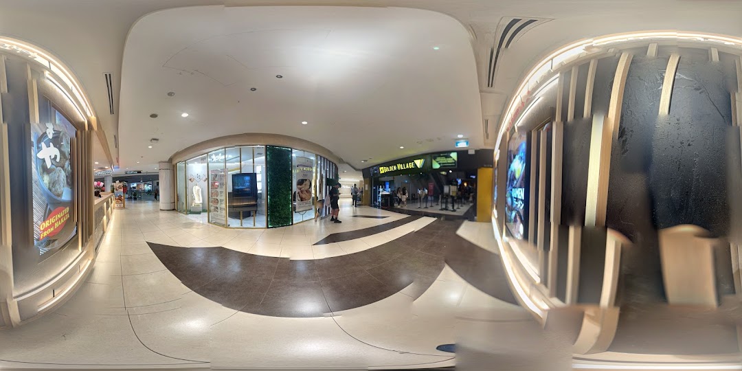View of Golden Village cinema entrance with queue barriers in a brightly lit mall corridor.