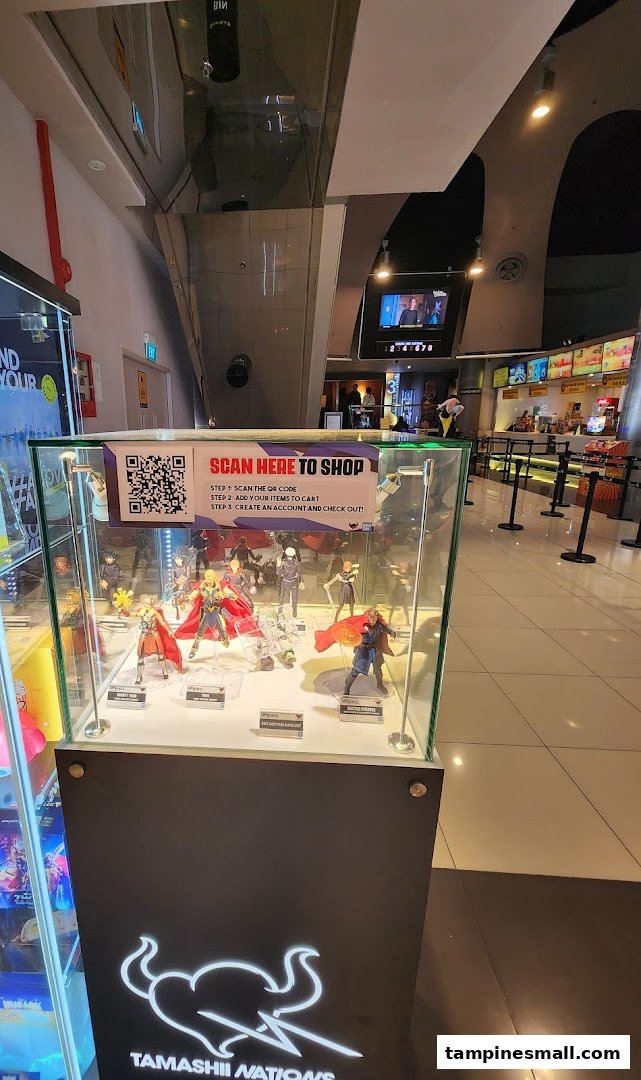 Interior view of Golden Village Tampines, showcasing a Tamashii Nations action figure display with QR code shopping.