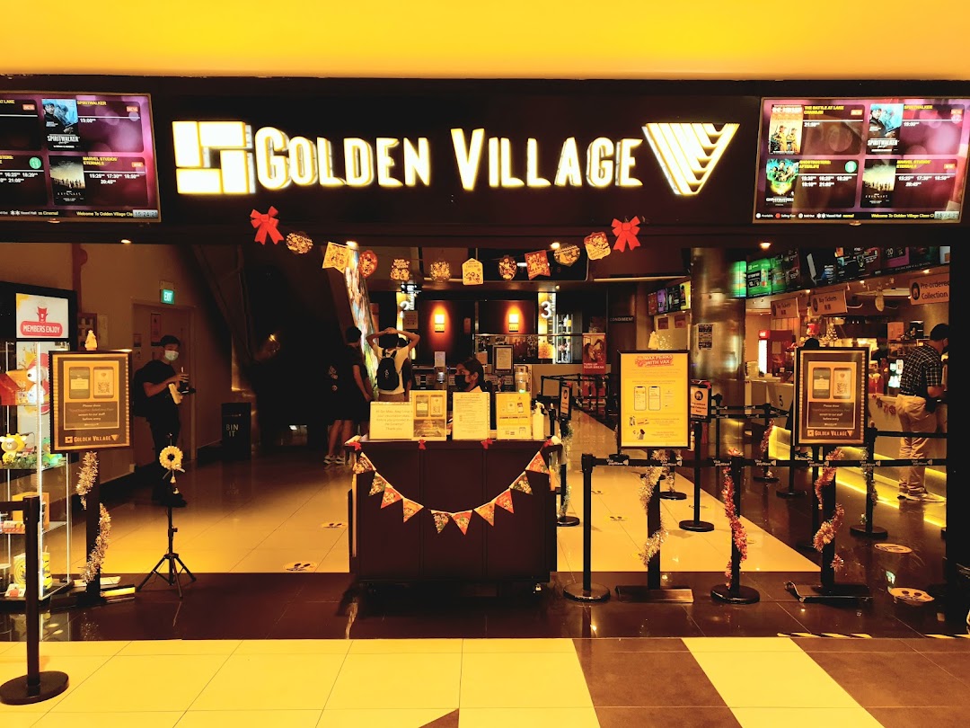 The brightly lit entrance of Golden Village cinema with movie screens and festive decorations.