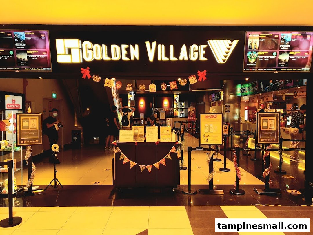 The brightly lit entrance of Golden Village cinema with movie screens and festive decorations.