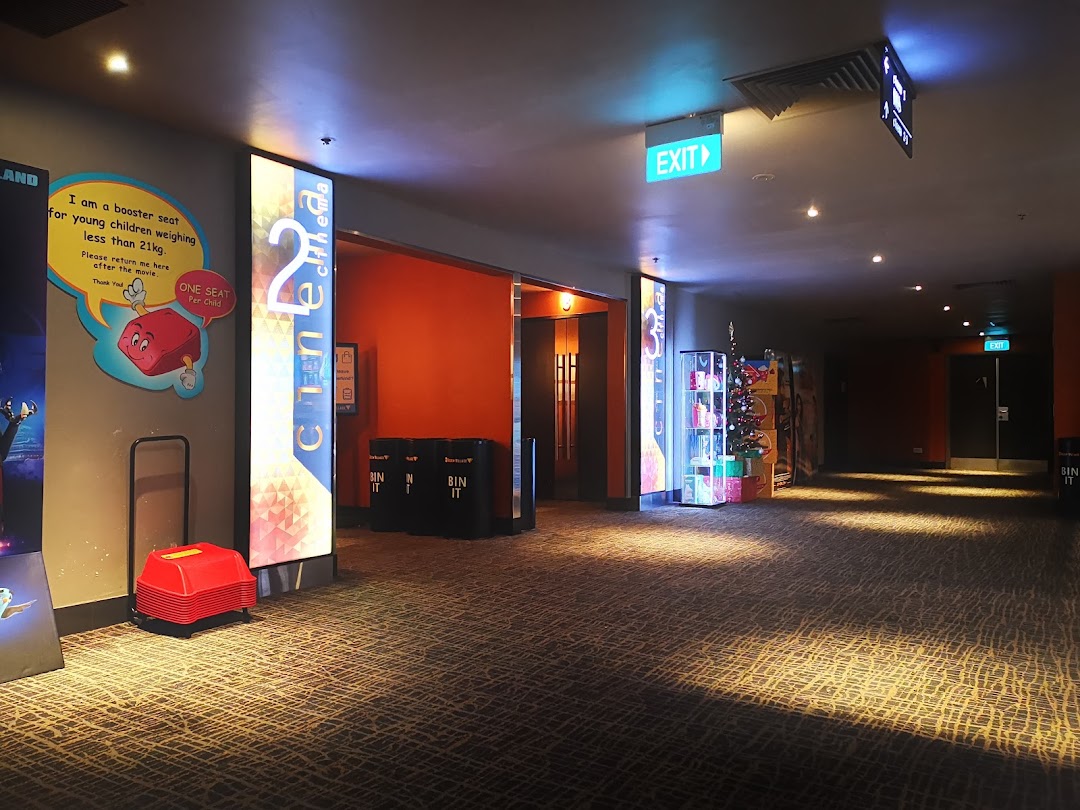 Interior view of Golden Village Tampines cinema hallway with signs and booster seats.
