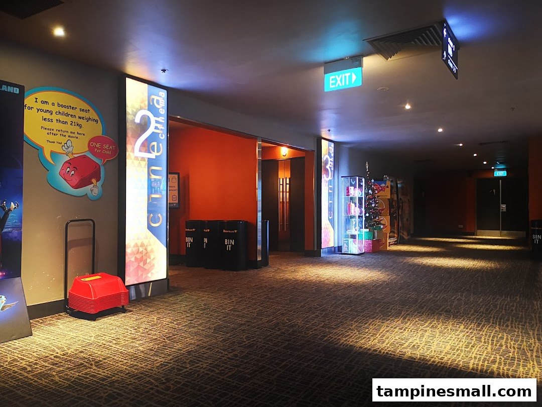 Interior view of Golden Village Tampines cinema hallway with signs and booster seats.