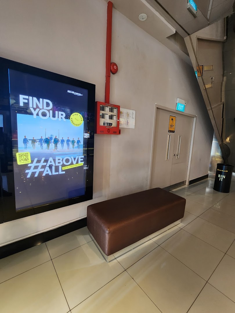 A comfortable waiting area at Golden Village Tampines with a digital display and seating.