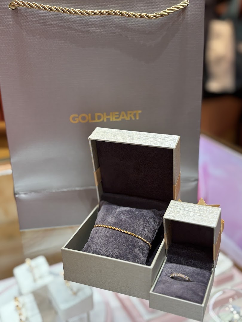 Goldheart jewelry pieces, including a bracelet and ring, displayed with a branded shopping bag.
