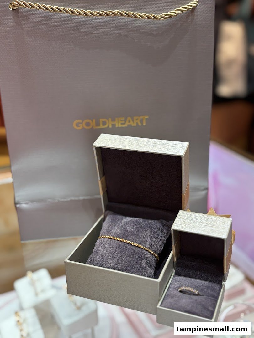 Goldheart jewelry pieces, including a bracelet and ring, displayed with a branded shopping bag.
