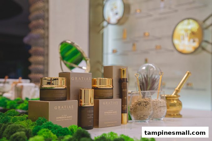 A display of GRATiAE skincare products, including creams and serums, on a moss-covered counter.