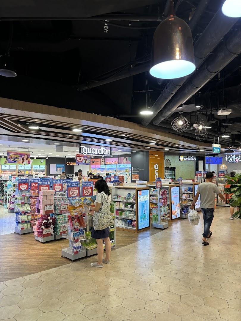 An interior view of Guardian Health & Beauty, showcasing various health and beauty products with customers browsing.