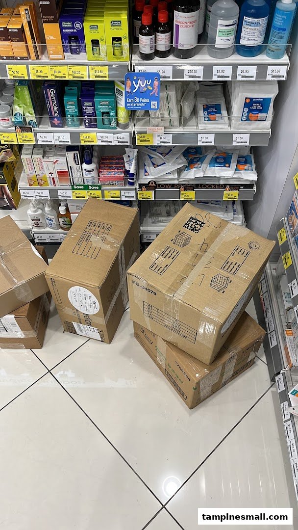 Interior view of a Guardian pharmacy aisle with products on shelves and delivery boxes.