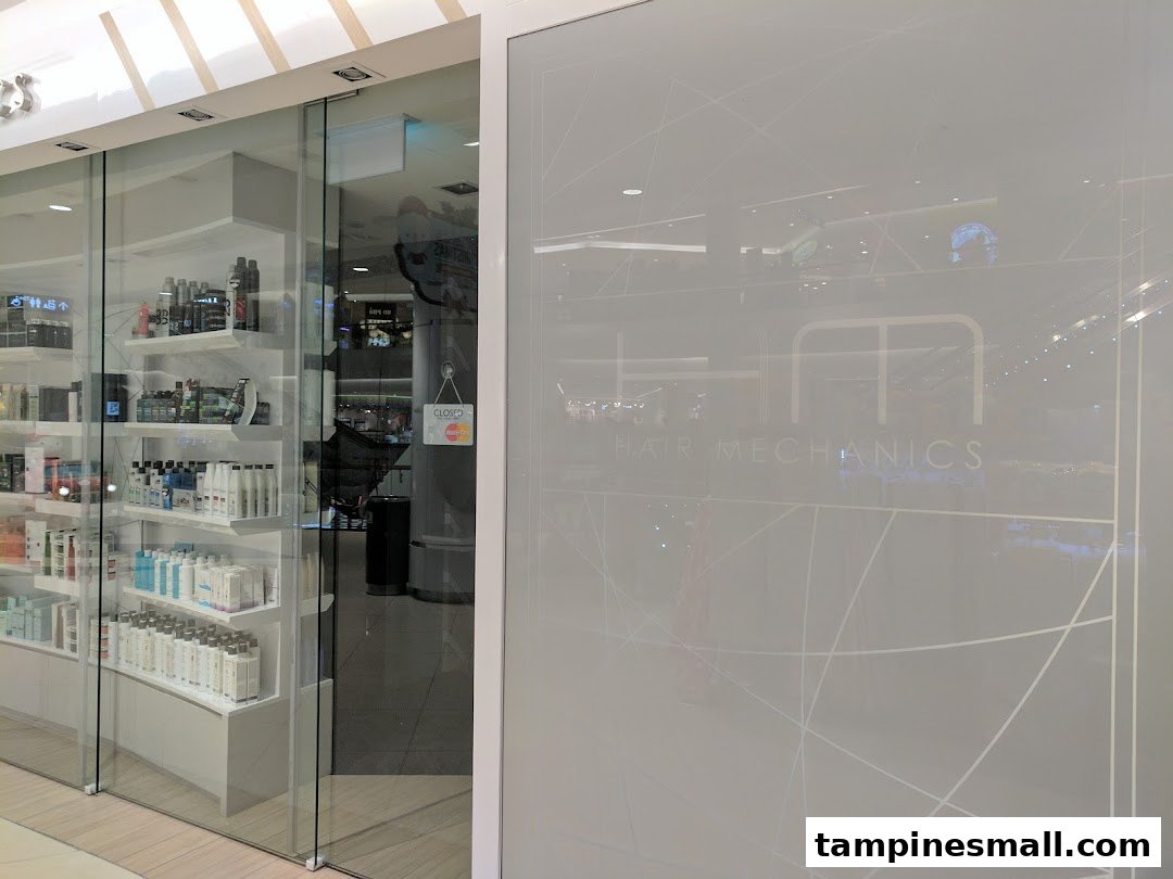 The glass storefront of Hair Mechanics, showcasing hair care products and the salon's entrance.