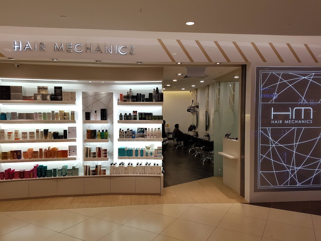 The brightly lit entrance of Hair Mechanics salon, showcasing product displays and a glimpse inside.