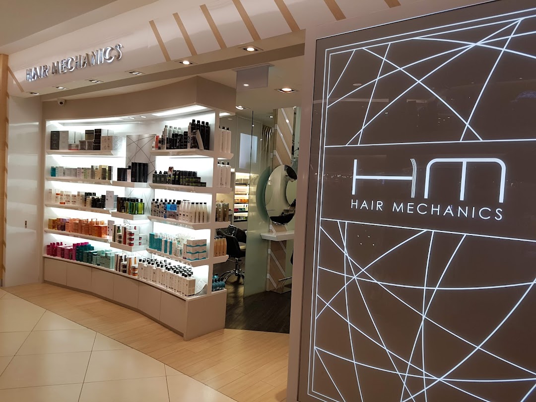 The brightly lit entrance and product display of the Hair Mechanics salon.