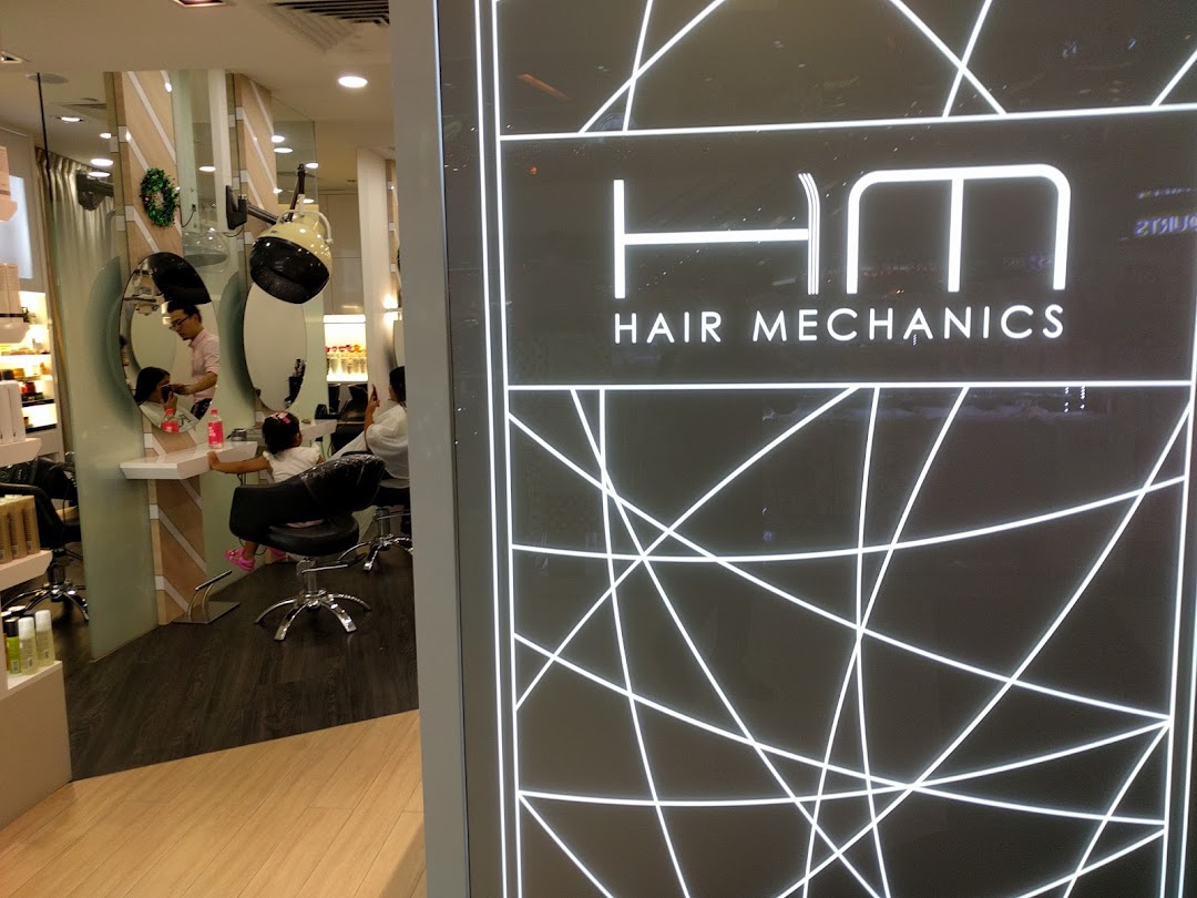 Interior view of Hair Mechanics salon showing a stylist attending to a child's hair.