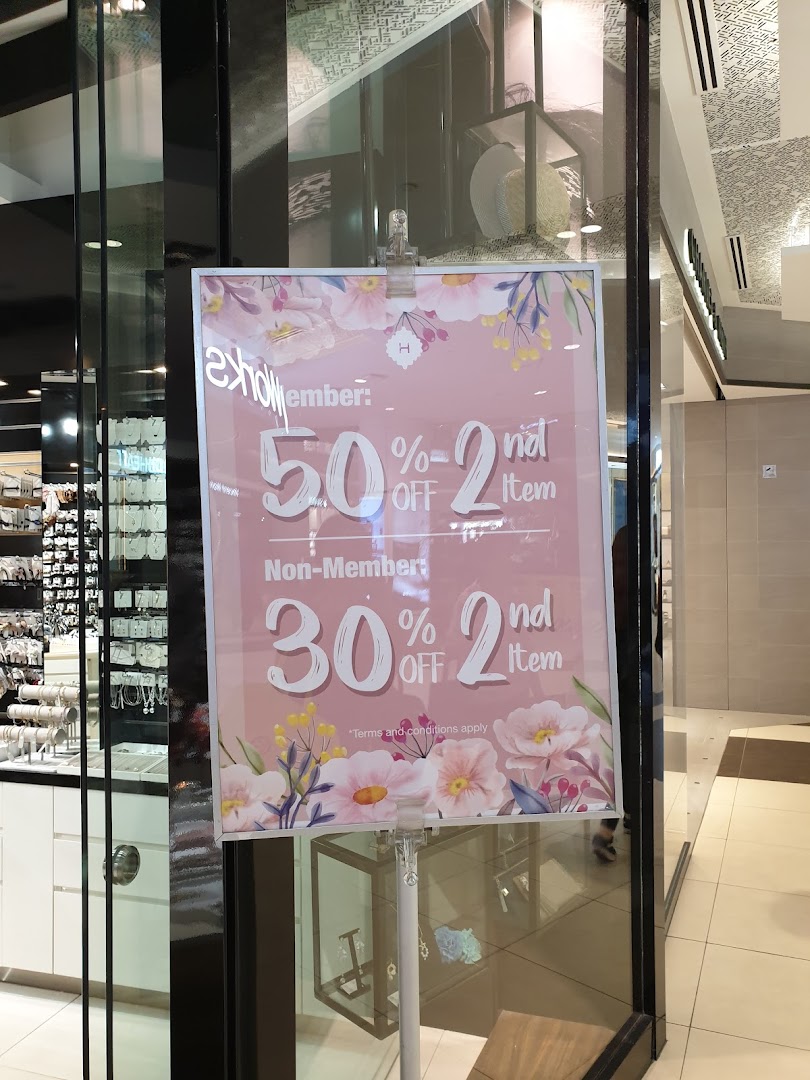 A promotional sign for Helen Tampines Mall offering 50% off for members and 30% off for non-members on the second item.