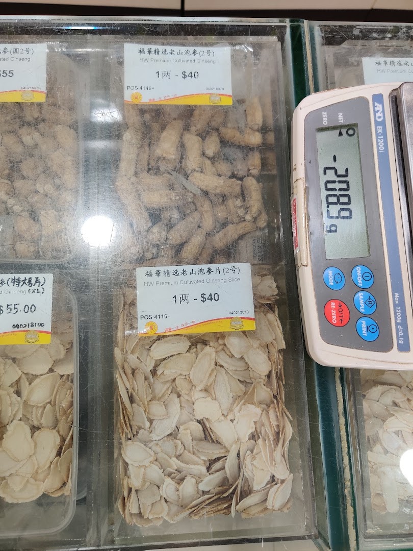 Close-up view of premium cultivated ginseng roots and slices displayed in clear containers with price labels and a weighing scale.
