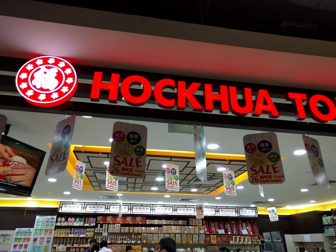 The illuminated Hockhua Tonic shop sign above its entrance, showcasing health products and anniversary sale banners.