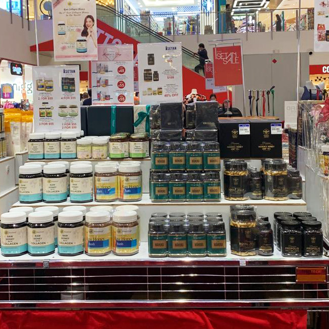 A retail display showcasing various HoneyWorld products like Manuka honey, collagen, royal jelly, and propolis.