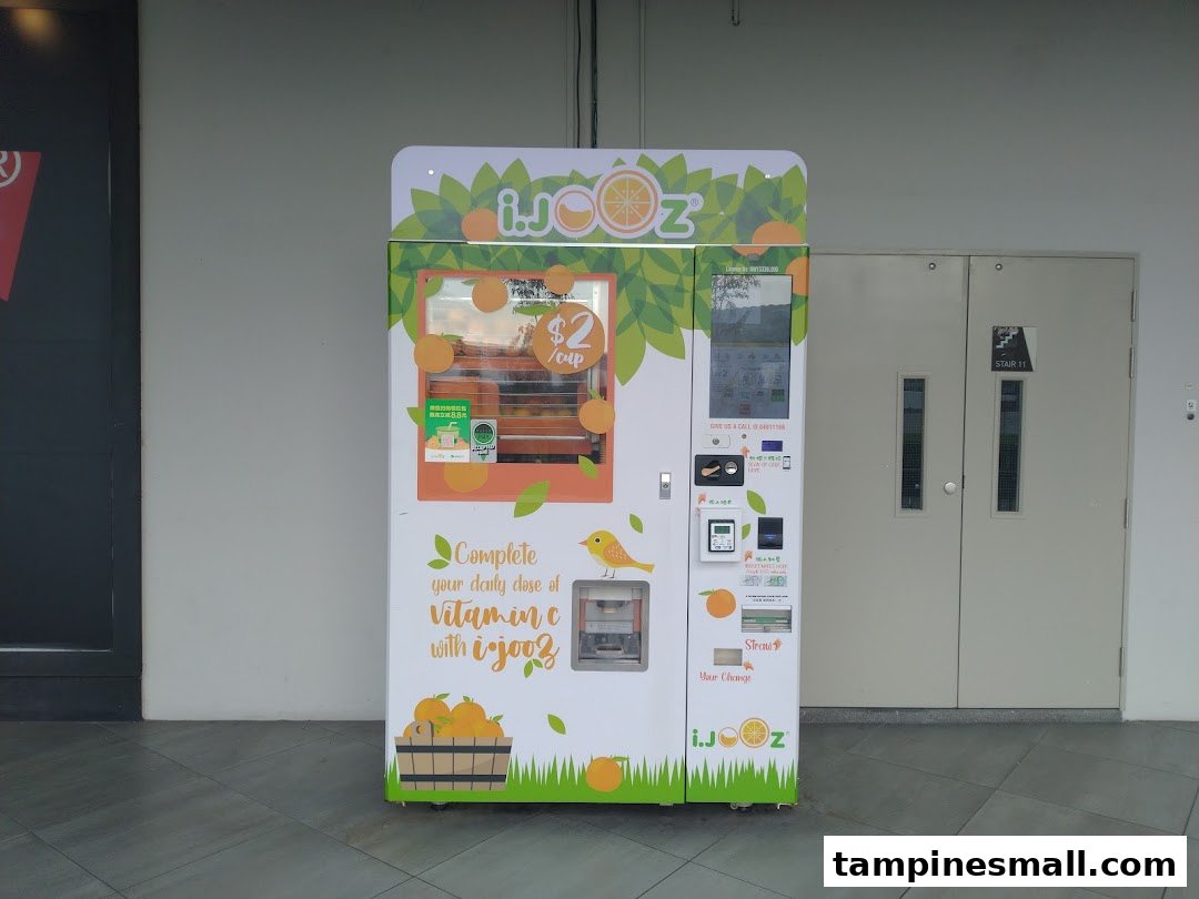 A vibrant iJooz fresh orange juice vending machine offering $2 per cup.