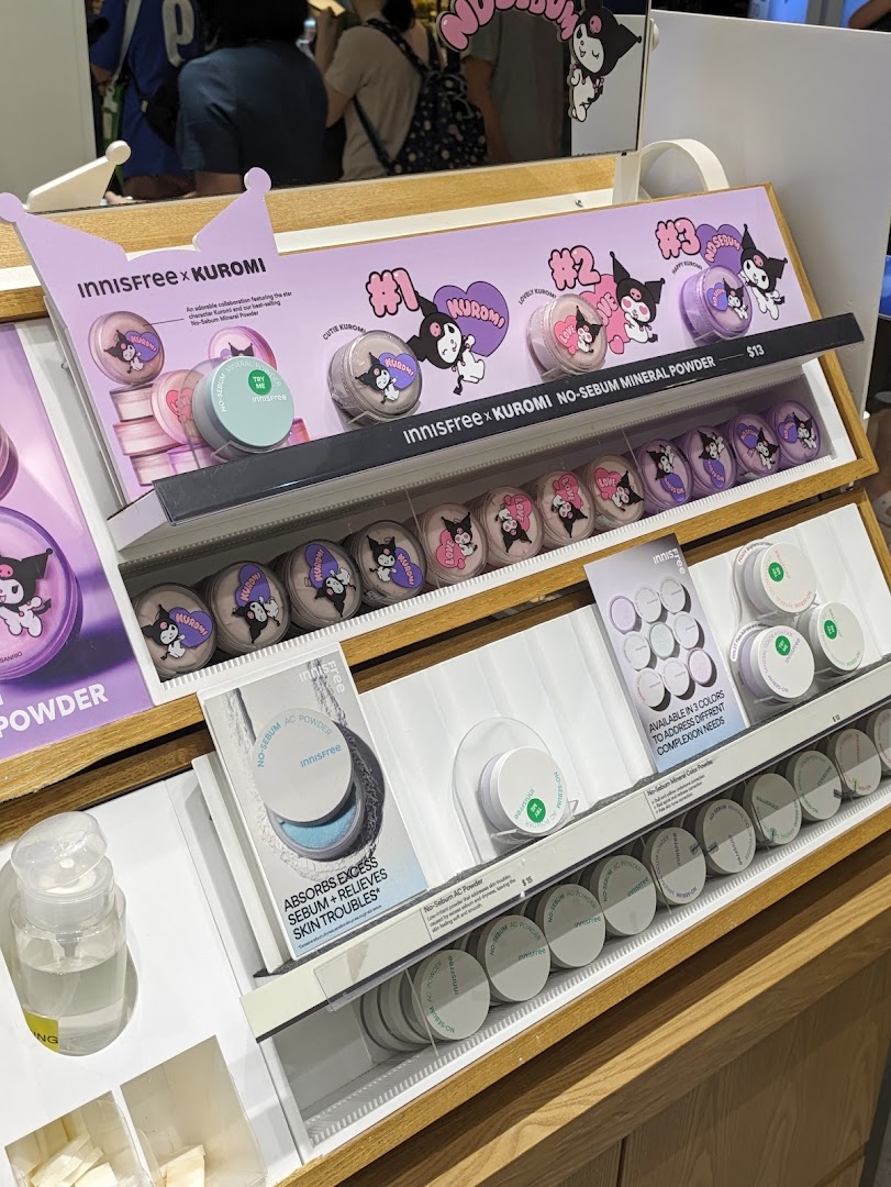 A display of Innisfree x Kuromi collaboration makeup and skincare products, including mineral powders and AC powder.