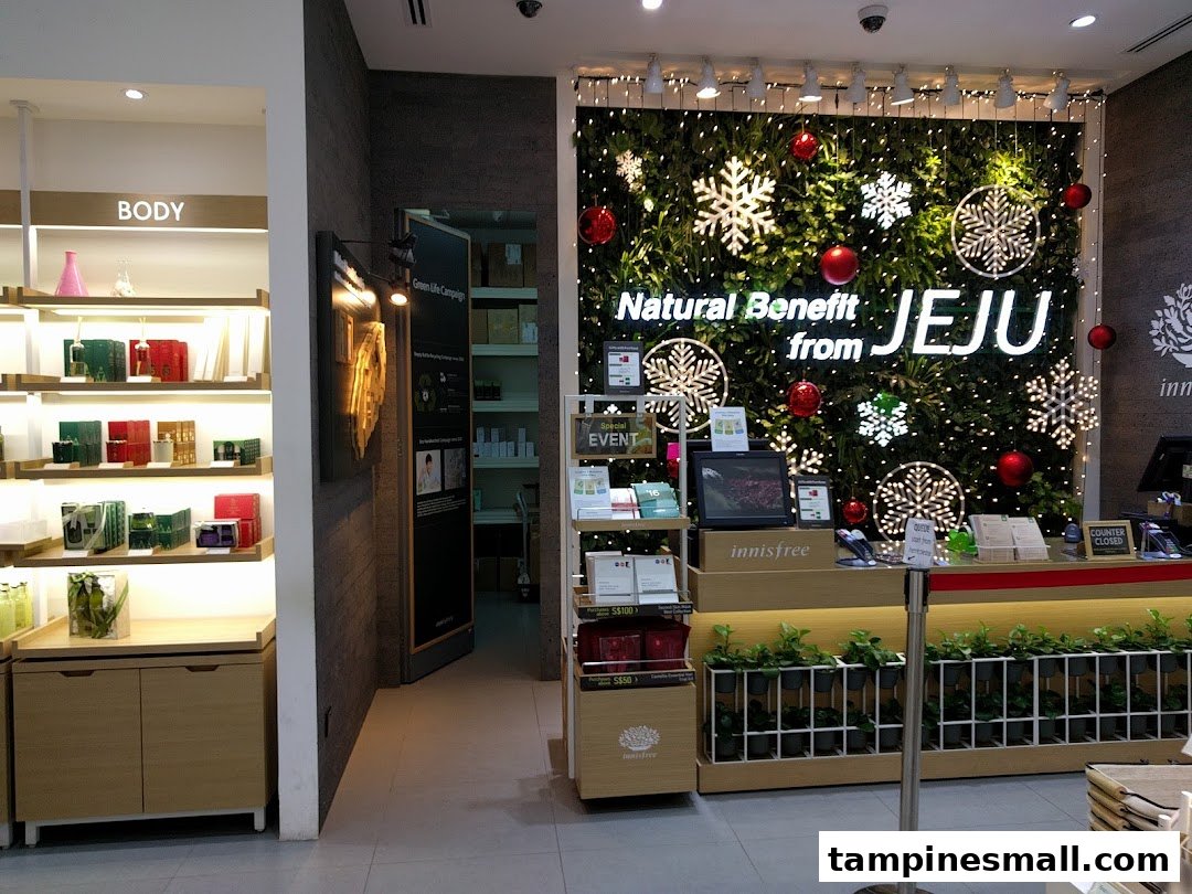 Interior view of Innisfree store featuring product displays, a counter, and a festive 'Natural Benefit from JEJU' wall.
