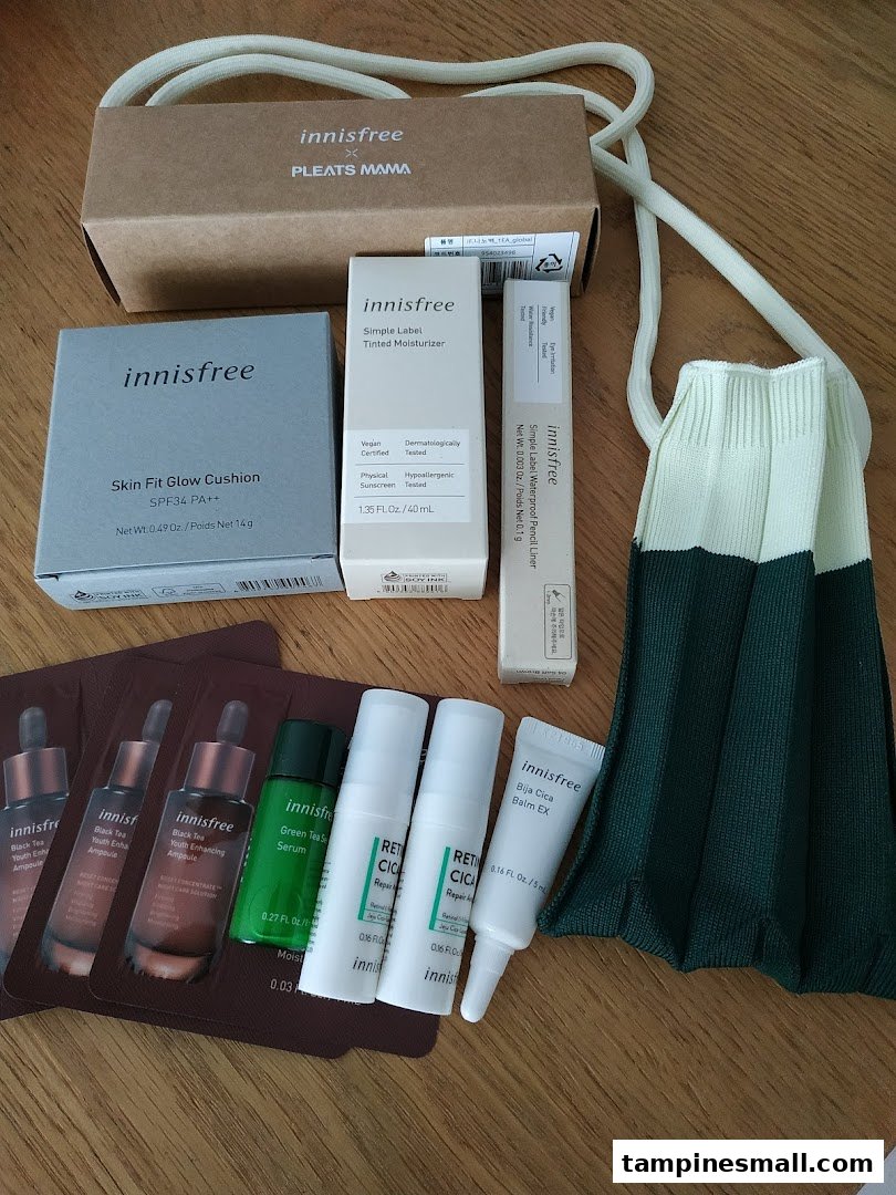 A collection of Innisfree skincare and makeup products, including cushions, moisturizers, and samples, displayed with a reusable bag.