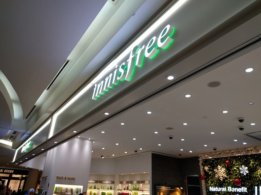 The innisfree shop entrance with its distinctive green and white illuminated signage.
