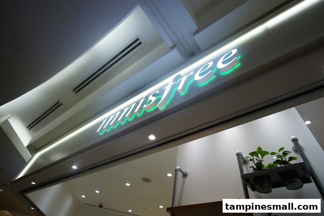 The illuminated Innisfree logo with green accents above the shop entrance.