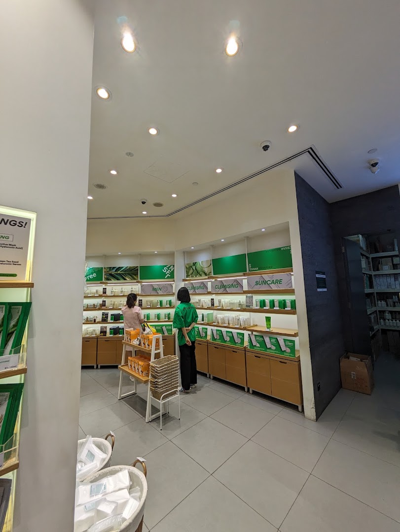 Two customers browse skincare products displayed on shelves in a brightly lit Innisfree store.
