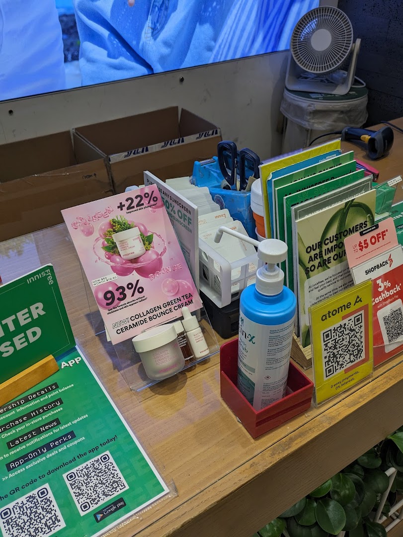 A detailed view of an Innisfree store counter showcasing skincare products, promotions, and app download QR codes.