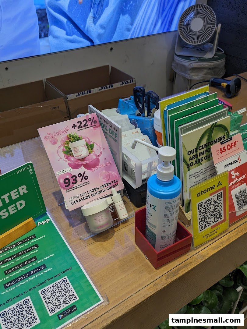 A detailed view of an Innisfree store counter showcasing skincare products, promotions, and app download QR codes.