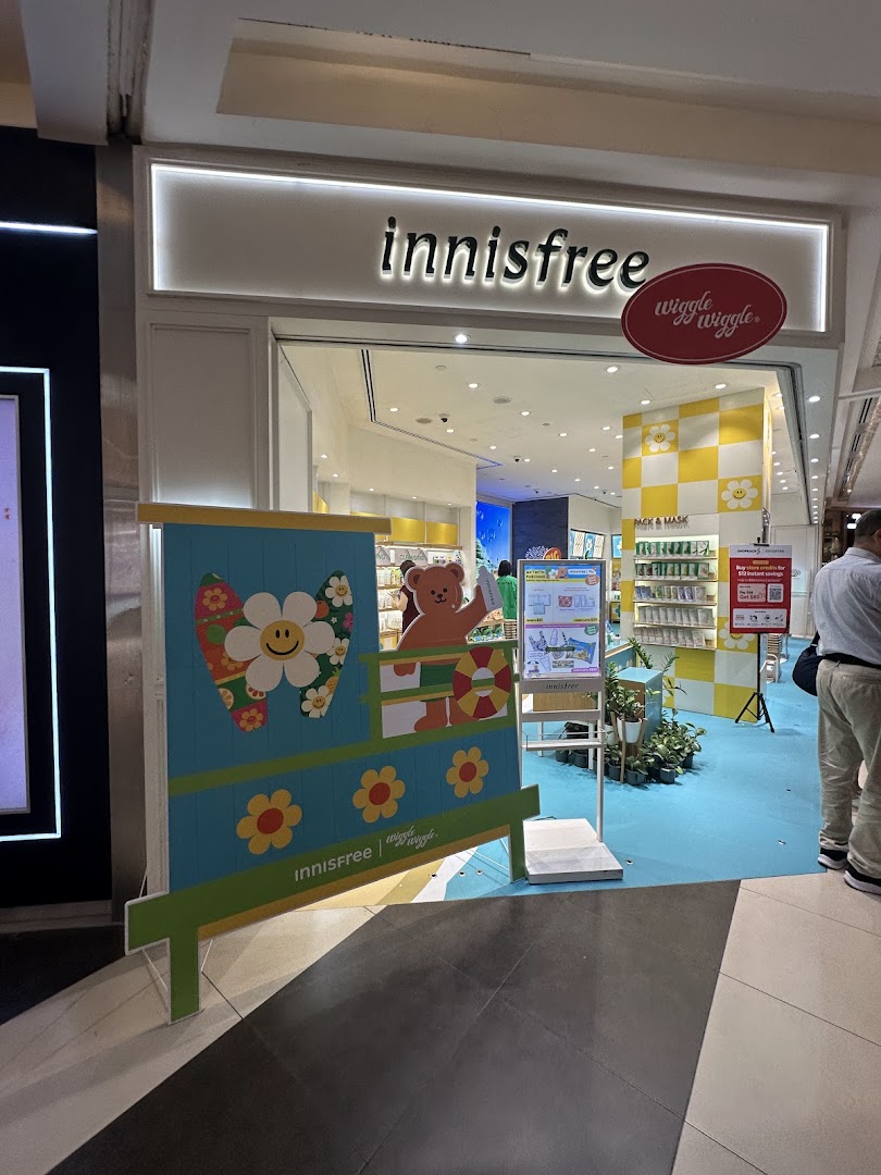 The Innisfree shop entrance features a vibrant Wiggle Wiggle collaboration display with a teddy bear.