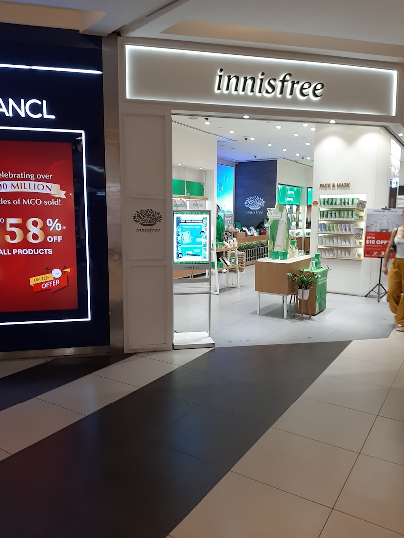 The image shows the brightly lit entrance of the innisfree beauty store with product displays visible inside.