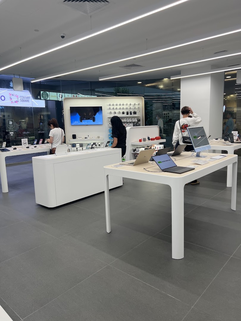 Customers browse Apple products and accessories in a brightly lit, modern iStudio retail store.