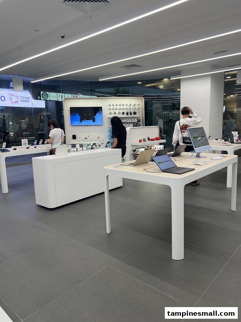 Customers browse Apple products and accessories in a brightly lit, modern iStudio retail store.