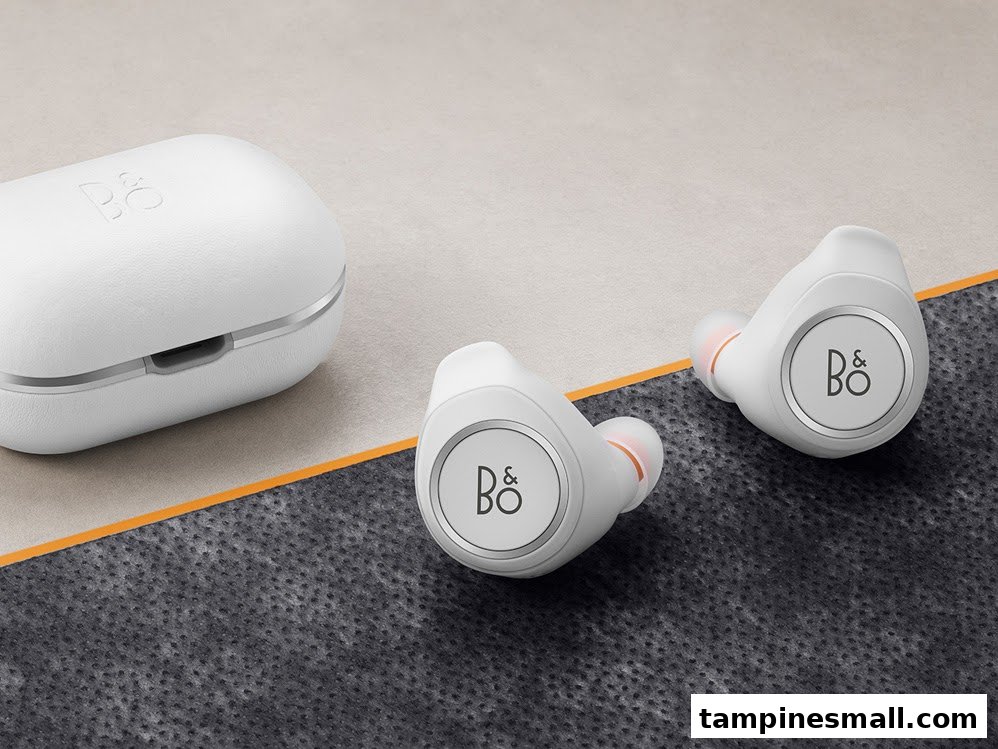 Close-up of white Bang & Olufsen wireless earbuds and their matching charging case.