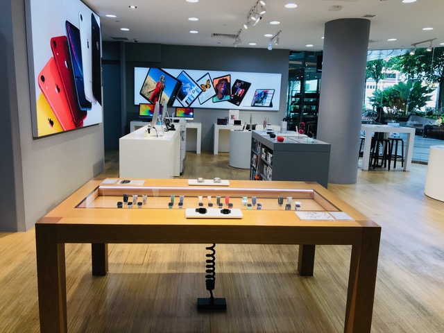 Interior view of iStudio, showcasing Apple products like iPhones, iPads, and Apple Watches on modern displays.