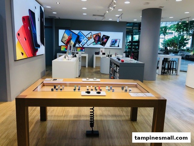 Interior view of iStudio, showcasing Apple products like iPhones, iPads, and Apple Watches on modern displays.