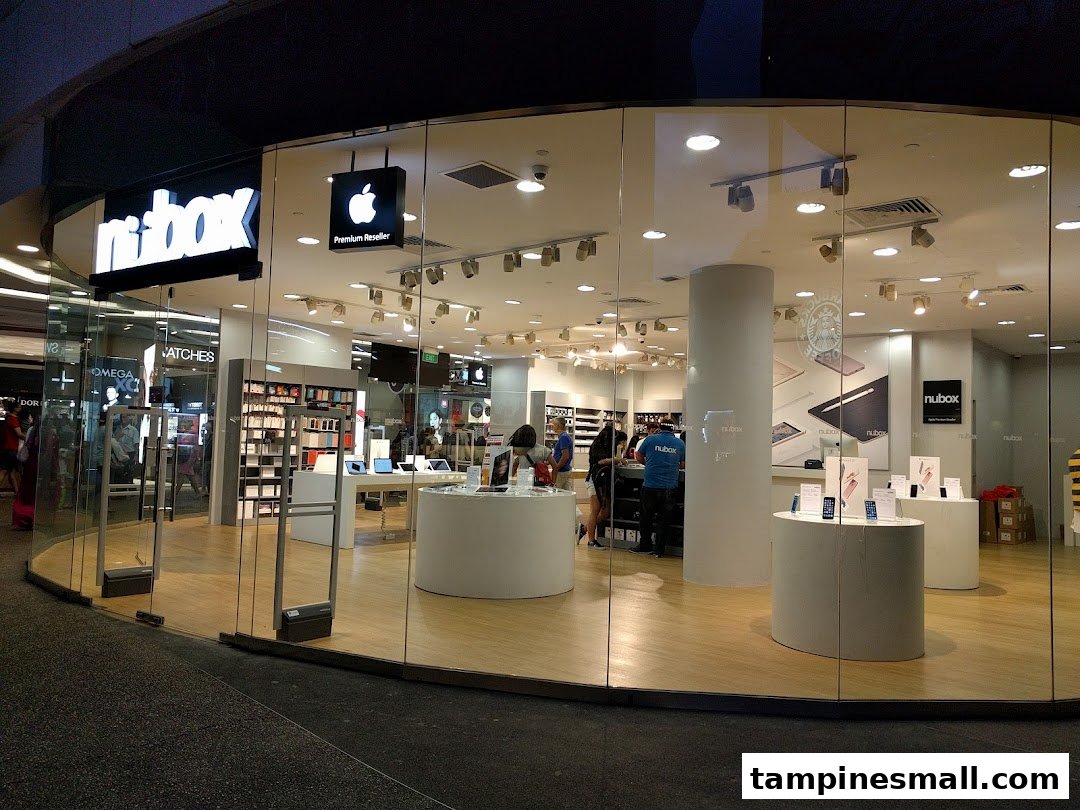 The brightly lit glass facade of an Apple Premium Reseller shop, 'nubox', showcasing its interior.