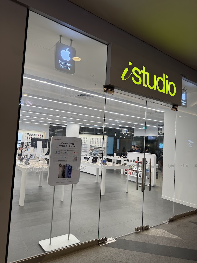 The glass entrance of iStudio Tampines Mall, an Apple Premium Partner store, showcasing its bright interior.