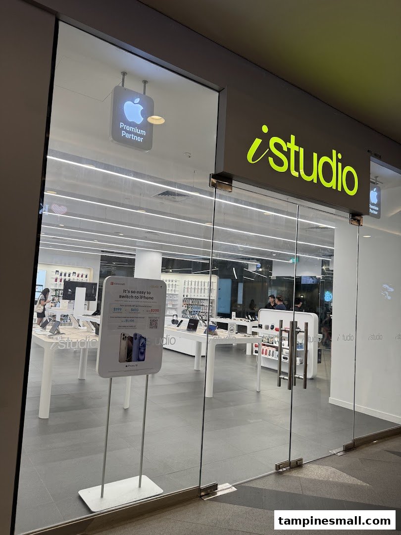 The glass entrance of iStudio Tampines Mall, an Apple Premium Partner store, showcasing its bright interior.