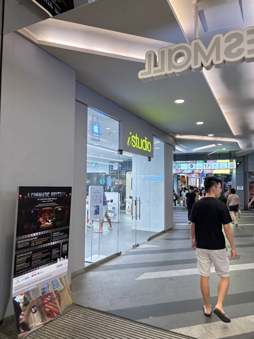 The iStudio shop front with its glass entrance and Apple logo, located in a mall corridor.