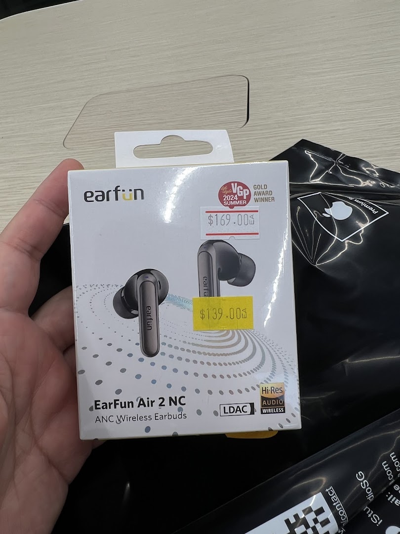 A hand holds a box of EarFun Air 2 NC ANC Wireless Earbuds with visible price tags.