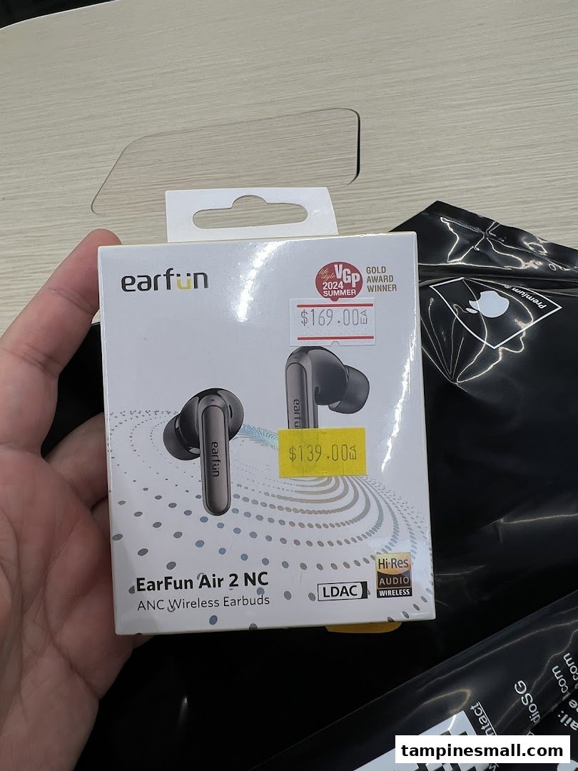 A hand holds a box of EarFun Air 2 NC ANC Wireless Earbuds with visible price tags.