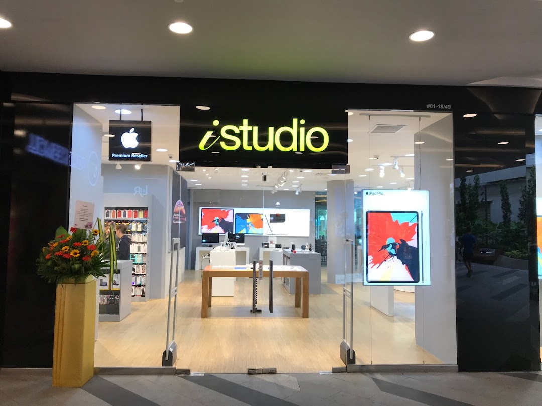 The iStudio shop front with its bright logo, glass entrance, and Apple Premium Reseller sign.